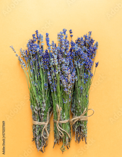 Bouquets of lavender flowers on a yellow background.
