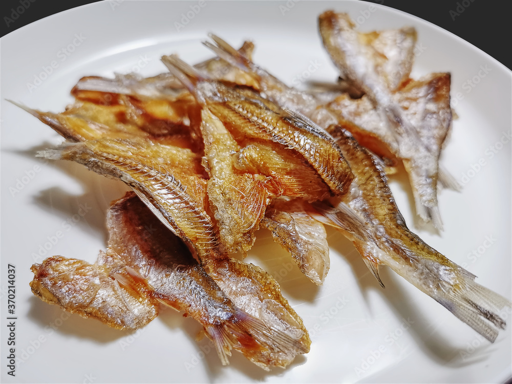 Crispy Fried Salted Fish on White Plate Crispy Fried Salted Fish on White Plate