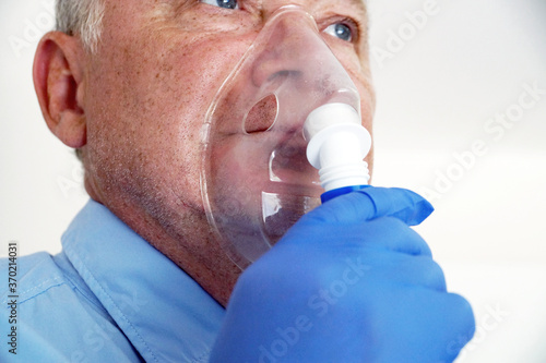 old man breathing through an inhaler, portrait close-up