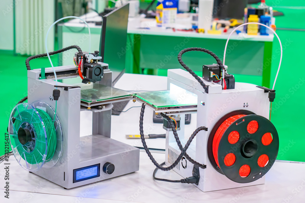 3D printers on the background of a technical laboratory. Devices for printing three-dimensional images. Technology for printing 3-dimensional objects. Equipment for layer-by-layer printing of models
