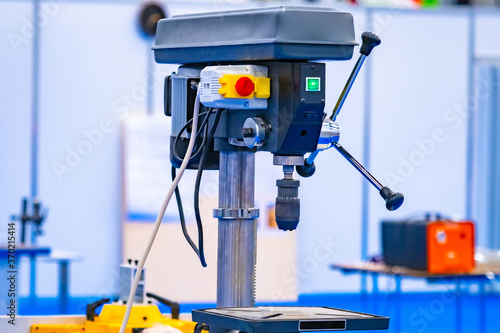 Vertical drilling machine close-up. Drill press with a vise. Equipment for Metalworking. Drilling equipment in the workshop. Machine for drilling holes in metal parts.
