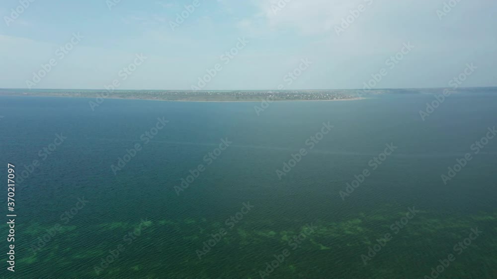 aerial drone view of a distant village on the bank of an estuary aerial drone view of a distant village on the bank of an estuary