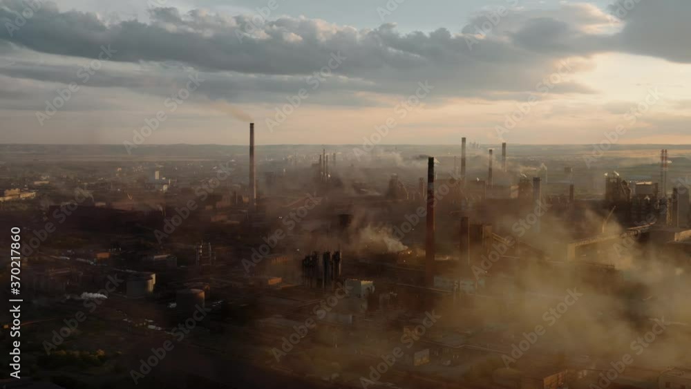 Drone shot of industrial zone with thick smog and burning fossil fuels. Factory zone pan shot from left to right, air pollution and soot in many factory chimneys in city area Drone shot of industrial zone with thick smog and burning fossil fuels. Factory zone pan shot from left to right, air pollution and soot in many factory chimneys in city area
