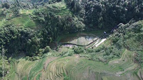 EPIC CINEMATIC REVERSE AERIAL OF THE REFLECTION OFF THE PINGAN RICE FIELDS photo