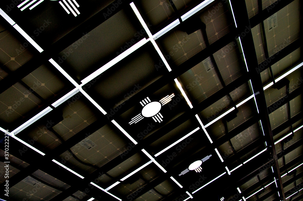 Φωτογραφία Underside of photovoltaic panels over parking stalls with Zia symbol cutout hono