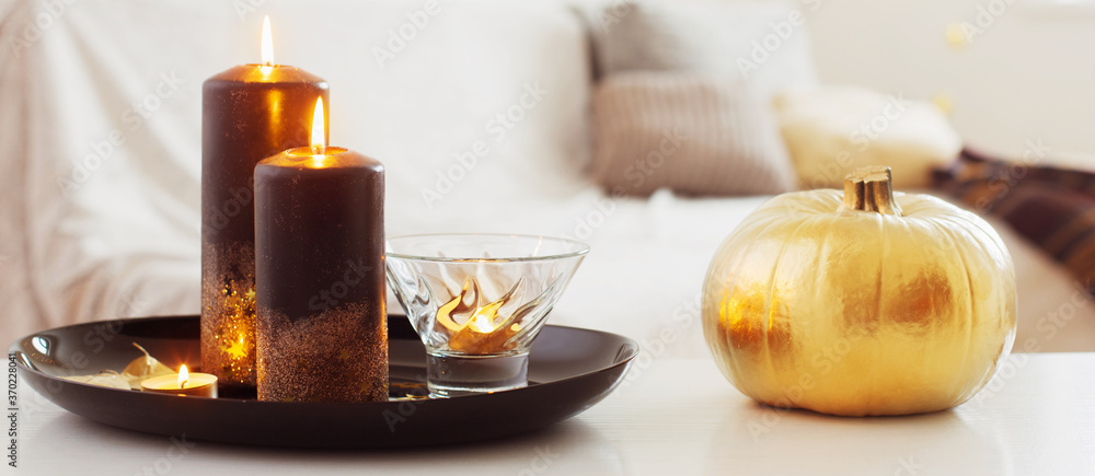 home decor with golden pumpkin and burning candles home decor with golden pumpkin and burning candles