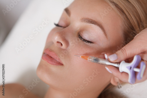 Attractive female patient getting vitamin skin injections at beauty salon