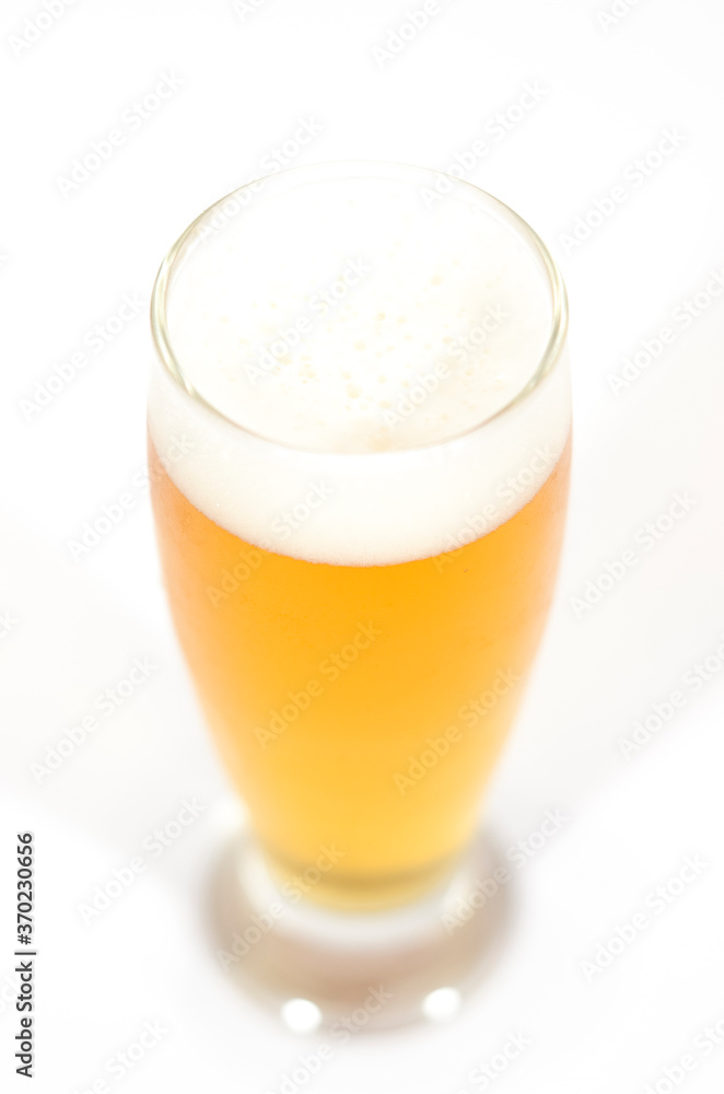 A glass of beer filled with foam centered in the image with a white background. A glass of beer filled with foam centered in the image with a white background.
