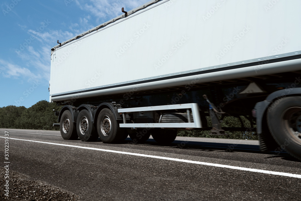 truck on the road, side view, empty space on a white container - concept of cargo transportation, trucking industry truck on the road, side view, empty space on a white container - concept of cargo transportation, trucking industry