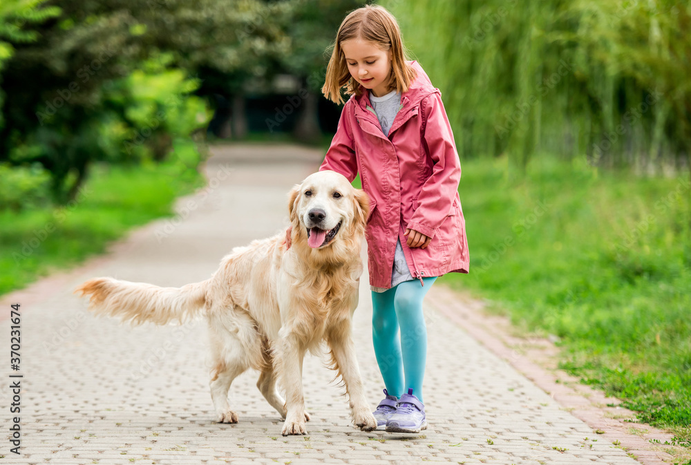 Little girl walking with golden retriever Little girl walking with golden retriever