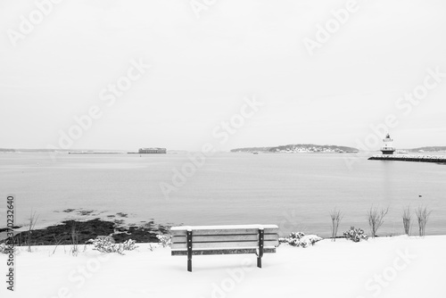 Snowy bench overlooking casco bay in Maine © benn
