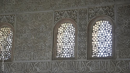 Beautiful pan shot of arabic stone writing and windows in the Alhambra