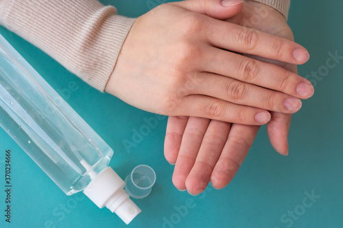 Top view of hands using spray bottle with antiseptic liquid. Concept of health care, self-hygiene and prevention of coronavirus spreading