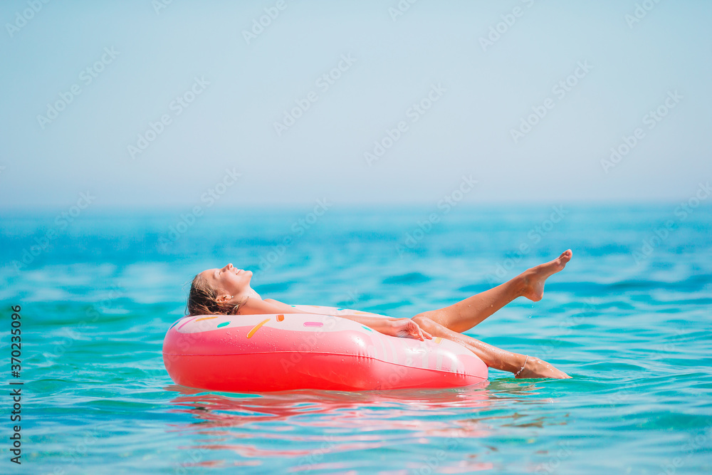 Adorable girl on inflatable air mattress in the sea Stock Photo | Adobe  Stock