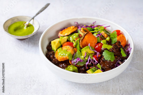 Vegan bowl with black beans, roast sweet potatoes, red cabbage and avocado