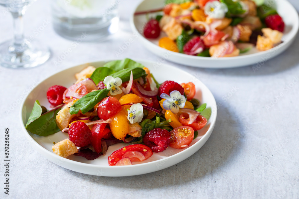 Summer panzanella salad with tomatoes, raspberries, basil and red onion Summer panzanella salad with tomatoes, raspberries, basil and red onion