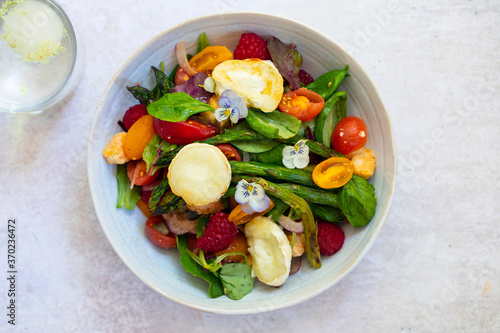 Summer panzanella salad with tomatoes, raspberries, basil and goat cheese