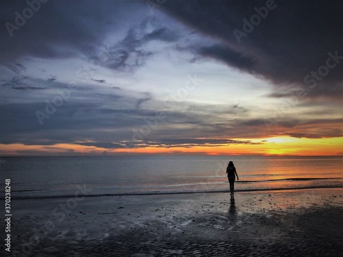 silhouette of a woman walking on the beach © Jenny