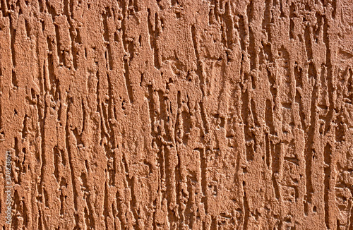 Brown decorative relief plaster. stucco wall. Brown background of the wall.