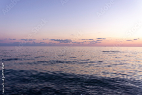 Seascape at purple sunset Blue water and cloudy purple sky Landscape Backdrop very peri copy space