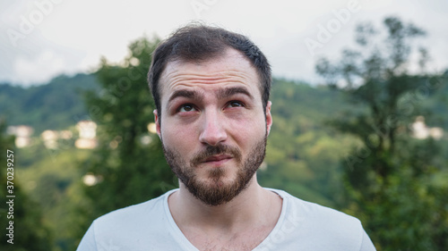Young white-skinned handsome man with unstable problems in nature