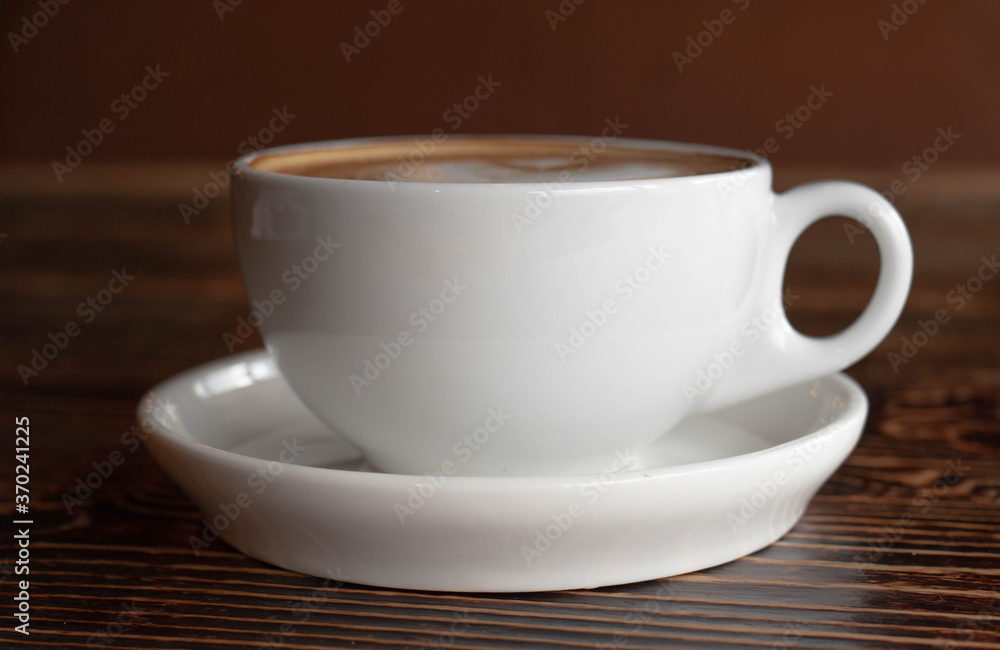 a white ceramic cup of cappucino as a coffee break concept a white ceramic cup of cappucino as a coffee break concept