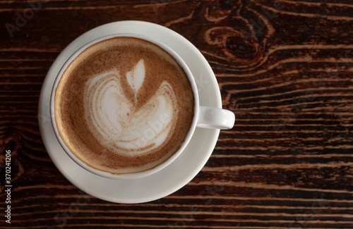 a white ceramic cup of cappucino as a coffee break concept