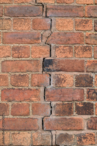 Close Up of Old Weathered Brick Wall with Large Central Vertical Crack 