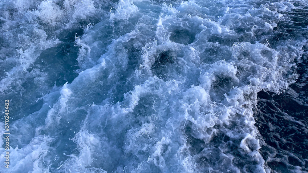 Seawater surface. White foam waves texture as a natural background. Seawater surface. White foam waves texture as a natural background.