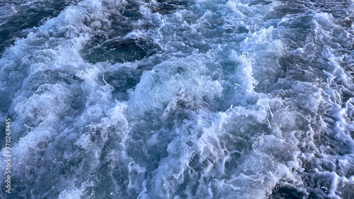 Seawater surface. White foam waves texture as a natural background.