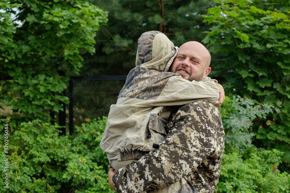 father and son in camouflage outside, father's day concept and greetings, laser tag military war game, father's return home father and son in camouflage outside, father's day concept and greetings, laser tag military war game, father's return home
