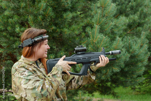 Girl playing in lasertag shooting game, girl with a gun, war simulation.
