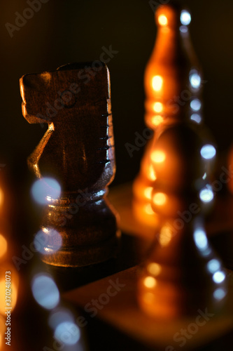 Close-up of wooden chess on a chessboard at night. photo