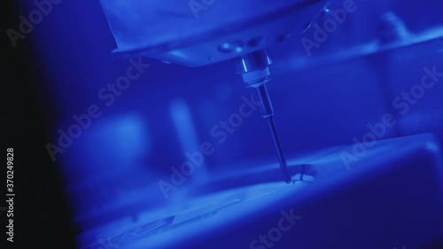 Slow motion works of the dental milling machine processing of carving out shape of human teeth from dental milling machine in blue light technician dentist construction close up