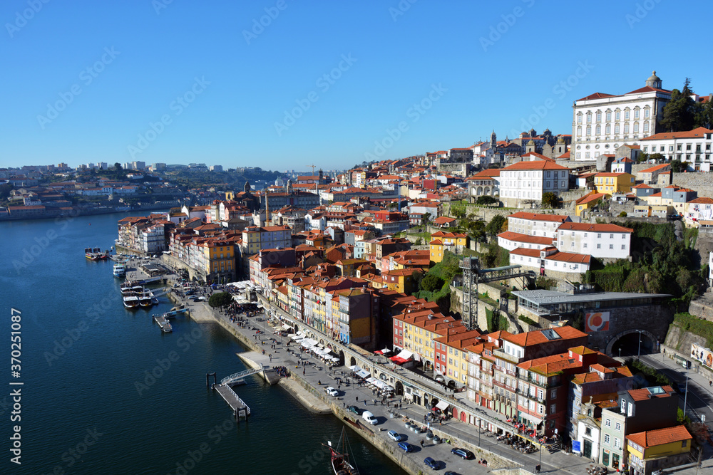 View from the bridge to the Porto embankment with moorings and buildings on a hill in the historic part of the city