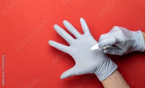 Medical gloves, antibacterial sanitizer gel - Virus protection equipment on red background. Clear sanitizer in pump bottle. Corona Virus pandemic protection by washing hands frequently photo