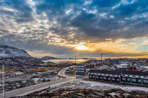 Arctic houses growing on the rocky hills in sunset panorama. Nuuk, Greenland