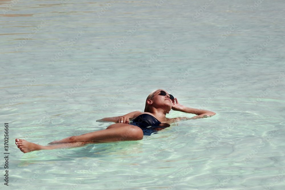 young woman relaxing in the dead sea 