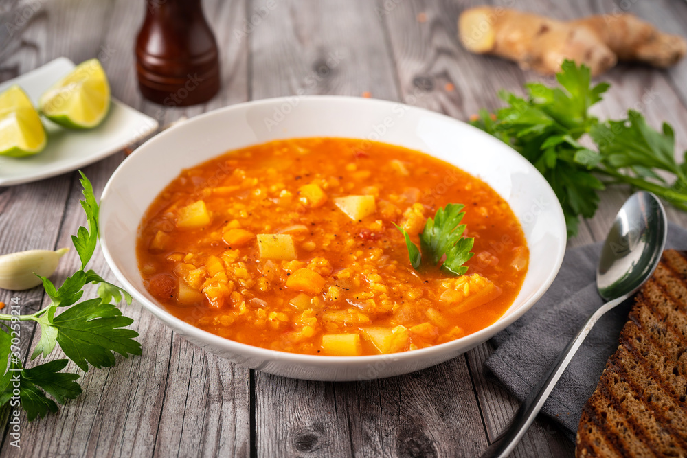 Spicy red lentil soup on gray wooden table Spicy red lentil soup on gray wooden table