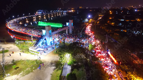 Aerial view of nighttime fountain attraction at Surabaya bridge, East Java, Indonesia which attracts local tourists
