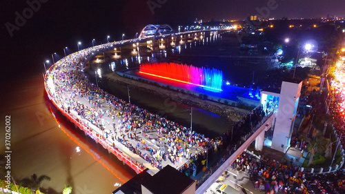 Aerial view of nighttime fountain attraction at Surabaya bridge, East Java, Indonesia which attracts local tourists
