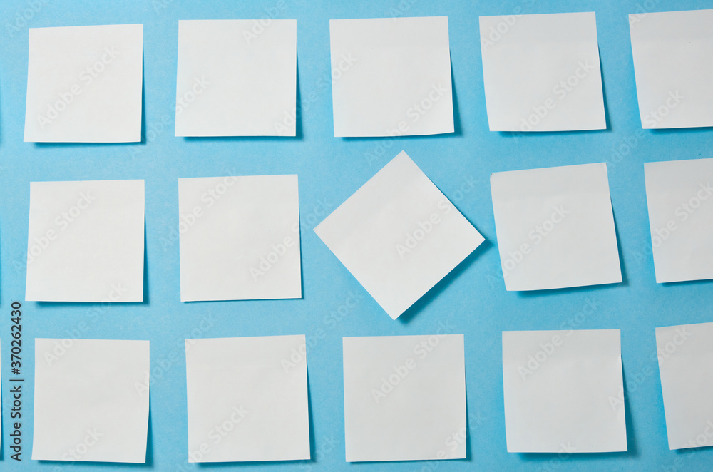 a lot of light blue paper stickers on a blue background, a pattern of stickers for notes, mock up, copy space a lot of light blue paper stickers on a blue background, a pattern of stickers for notes, mock up, copy space