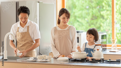 キッチンで料理を作る女の子と両親