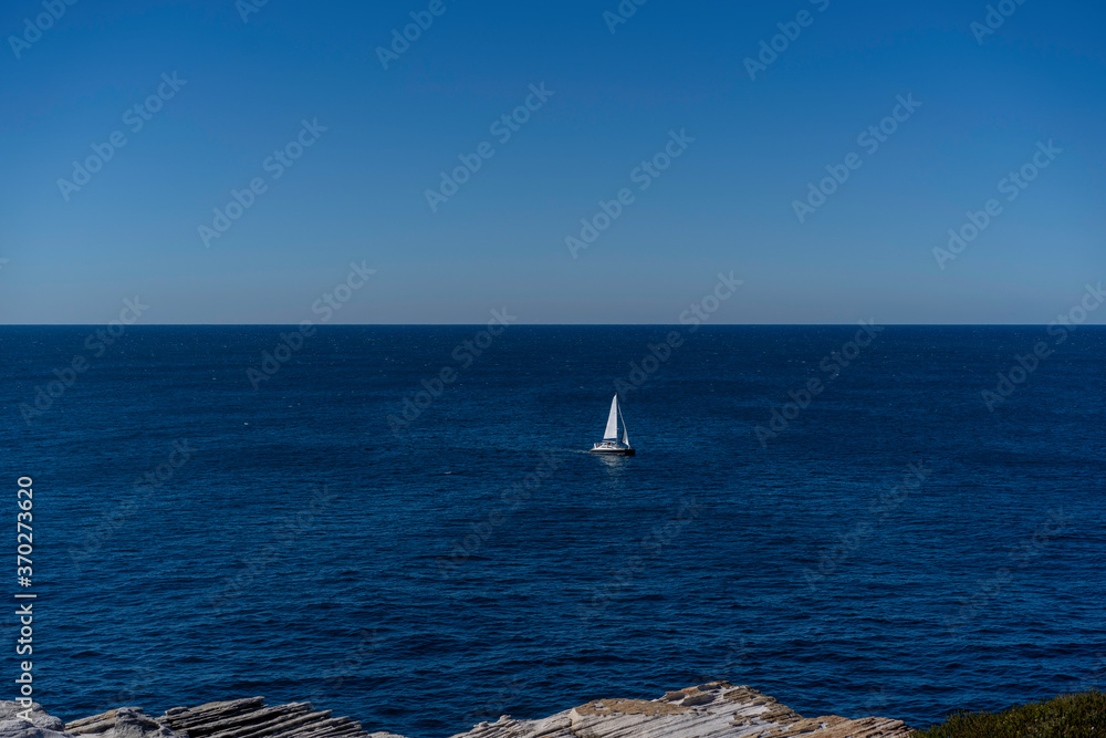 Obraz premium Seascape of the beautiful blue ocean/ sea with a Yacht Sailing in the sea