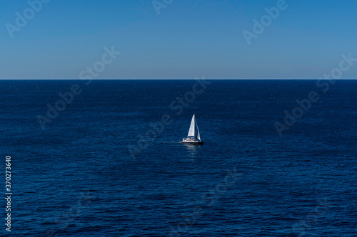 Seascape of the beautiful blue ocean/ sea with a Yacht Sailing in the sea