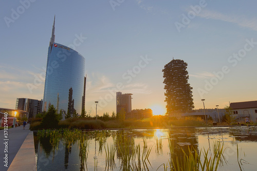 Milan, Italy - August 8, 2020: street view of Milan during the blue hour. Aulenti Square is visible with the UniCredit Tower skyscraper. photo