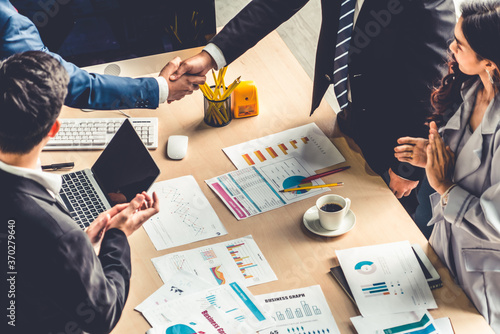 Фотография Group business people handshake at meeting table in office together with confident shot from top view
