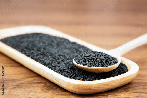 Black sesame seeds in a wooden spoon For healthy food and diet concepts.