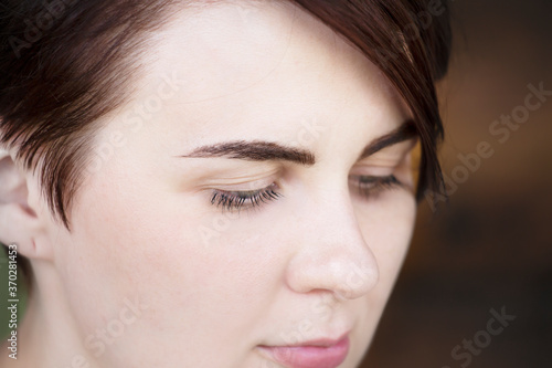 Portrait of a beautiful girl with lowered lashes