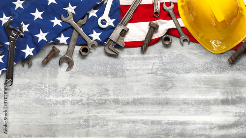 Labor day or American labor concept with construction and manufacturing tools on patriotic US, USA, American flag on white wooden background